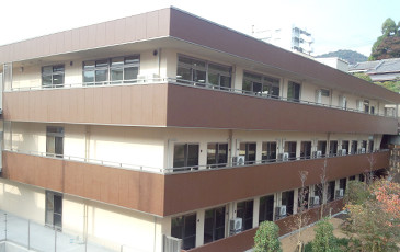 3階建ての介護施設の建物外観。モダンな設計で、複数の窓が配置された実写真です。